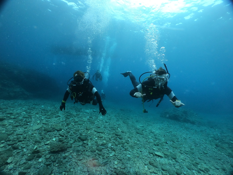 Me scuba diving to the right of my partner in Okinawa