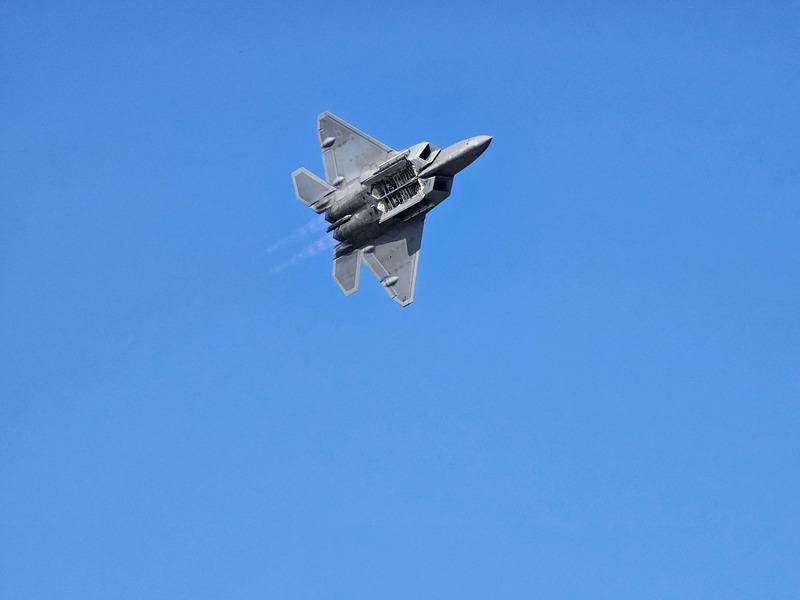 A F-22 Raptor from below with weapons bays open